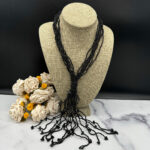 Multi-strand black bead necklace.