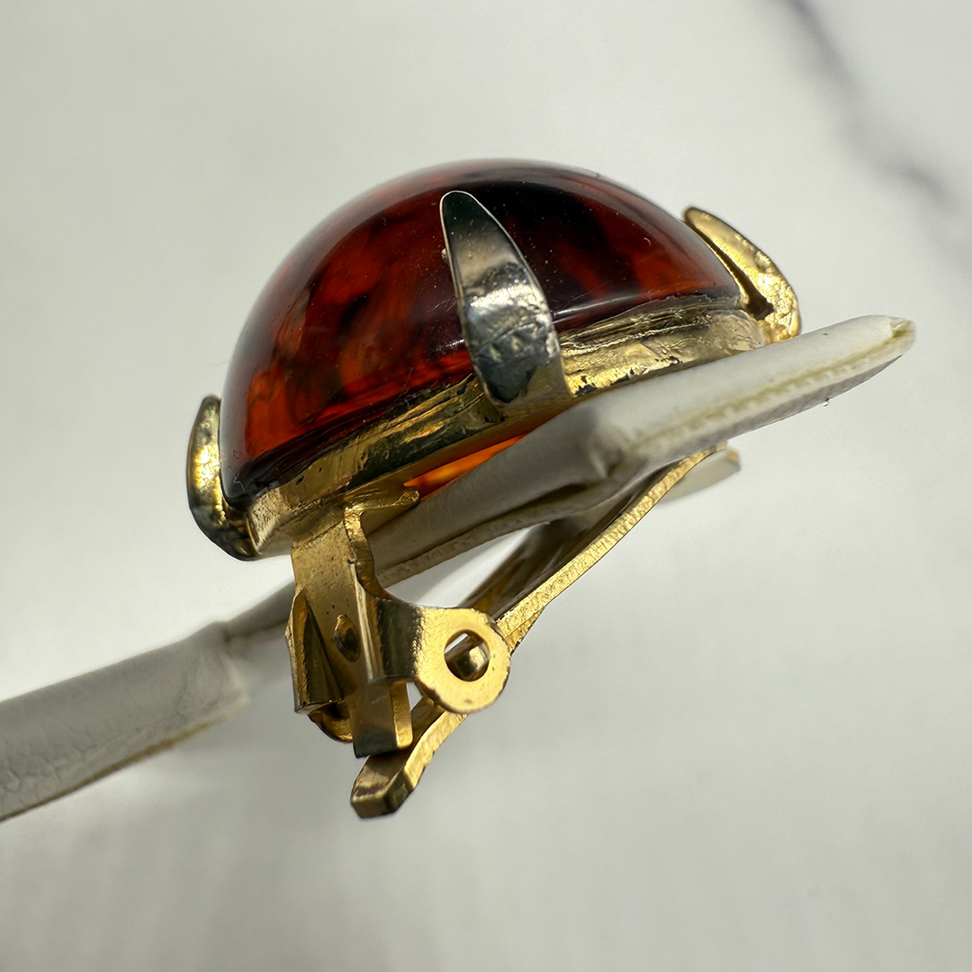 Vintage amber-colored resin button earring prong metal wear.